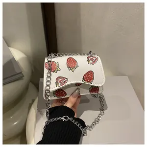 Detail der weißen PU-Schultertasche mit Erdbeerdruck und silberner Kette