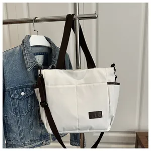 Détail d'un grand sac cabas avec poches latérales et bandoulières marron