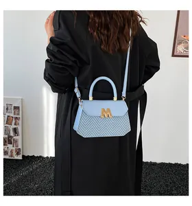 Dettaglio borsa a tracolla azzurra con logo M metallico e trama a V intrecciata