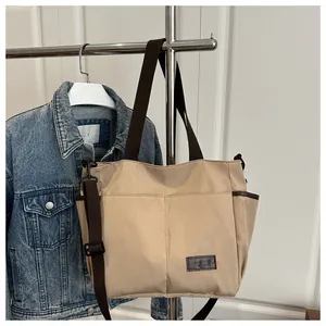 Détail du sac fourre-tout en toile kaki avec plusieurs poches et bandoulière réglable