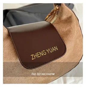 Gros plan des textures de daim et cuir avec fermeture éclair dorée sur un sac marron
