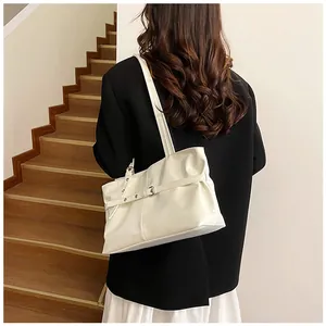 Close-up of the cream-colored faux leather shoulder bag with stylish metal buckle detail