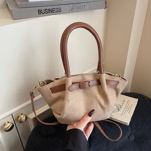 Minimalist beige suede handbag with brown leather straps and gold buckle detail