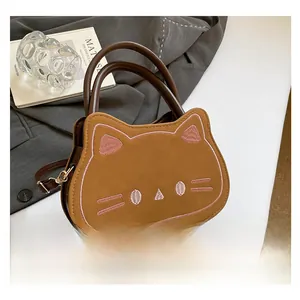 Macro detail of the cat-shaped brown faux leather handbag showing fine pink embroidery
