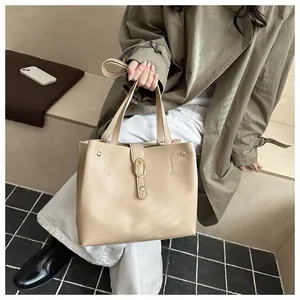 Detail view of beige PU leather tote bag with elegant golden buckle and minimalist design