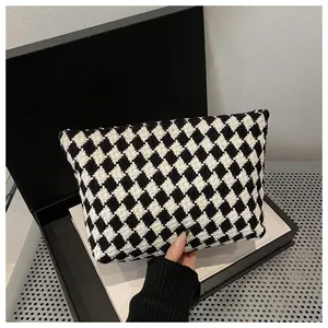 Macro shot of black and white checkered hand-held pouch showing textured weave detail
