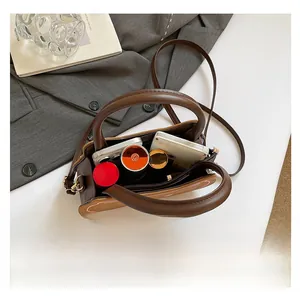 Interior view of brown mini crossbody bag showing storage capacity for phone and cosmetics