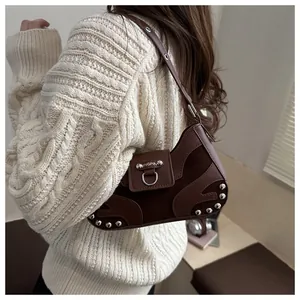 Close-up of brown suede hobo bag featuring silver rivets and metal hardware details