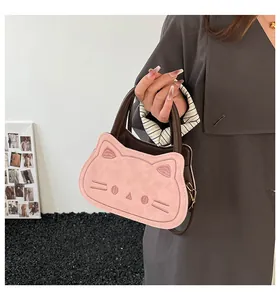 Detail of pink cat-shaped handbag featuring 3D ears and embroidered whiskers for fashion look