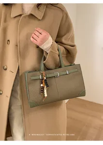 Detail of retro tote bag with olive green leather trim and multi-color wood bead charm