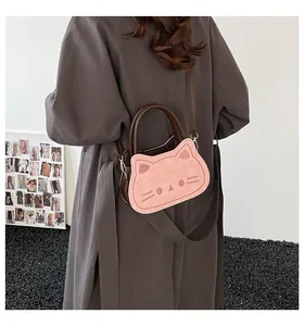 Close-up of pink cat-shaped handbag with brown handle and detailed facial embossing