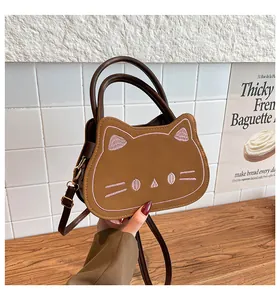 Detail of cute cat shaped brown leather handbag with pink embroidery and long shoulder strap