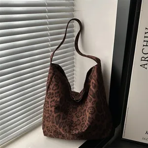 Brown leopard print hobo tote bag in a minimalist room with window shadows