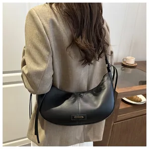 Detail einer schwarzen Hobo-Tasche aus Leder mit Falten-Design und Metallverzierung