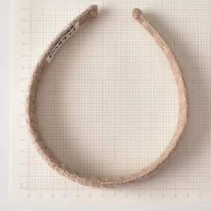 Détail d'un bandeau en maille marron clair montrant la texture et la taille d'environ 13cm