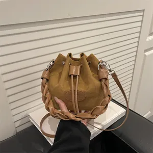 Brown faux suede bucket bag with woven handle and drawstring closure for women