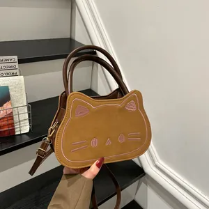 Brown cat-shaped crossbody bag with embroidery details and adjustable shoulder strap