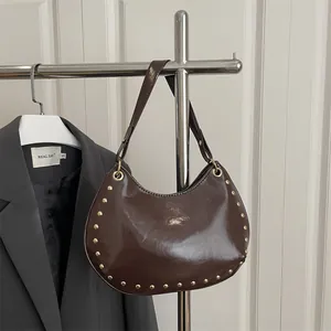 Dark brown faux leather crescent shoulder bag with golden studs and glossy finish