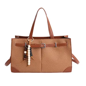 Brown woven texture tote bag with leather handles and decorative beaded tassel accessory
