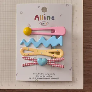 Detailed view of colorful 4-piece hair clip set including heart and wave designs on paper card