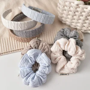 Gros plan de serre-têtes et chouchous en tricot torsadé aux couleurs pastel douces