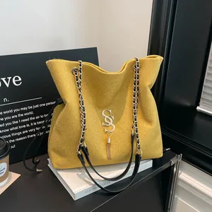 Bolso bandolera pequeño dorado brillante con logo metálico de doble S y borla lateral