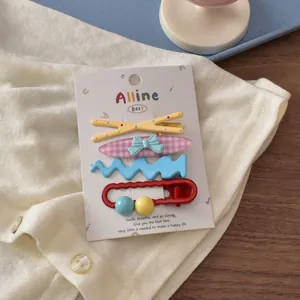 Detail of four colorful Korean hair clips with bear and bow designs on a display card