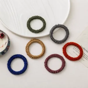 Détail d'un lot de six chouchous en maille aux couleurs d'automne sur un plateau blanc