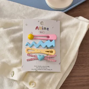 Close-up of a 4-piece set of colorful bear and bow hair clips on a card packaging