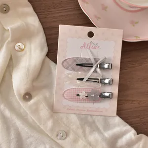 Detailansicht der 3-teiligen Haarspangen mit grauer Schleife und rosa Blumenclips auf Karte