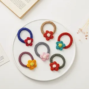 Détail de six chouchous tricotés à la main avec fleurs dans des couleurs vives et variées