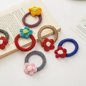 Lot de chouchous fleurs faits main au crochet en couleurs variées sur livre ancien