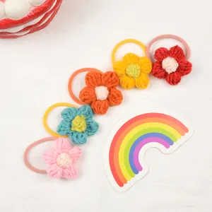Five handmade crochet flower hair ties for girls in pink, blue, orange, yellow, and red colors
