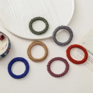 Élastiques à cheveux tissés à la main aux couleurs Morandi sur une assiette