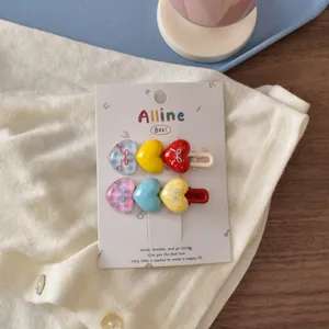 Detail of colorful heart hair clips with bow patterns on a branded white display card