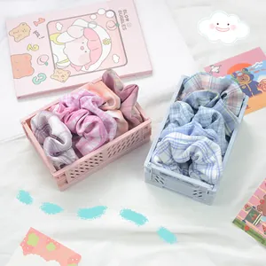 Gros plan de chouchous à carreaux colorés rangés dans des petits paniers sur tissu blanc
