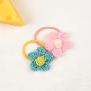Detailed view of handmade crochet flower hair ties in pink and blue knit textures