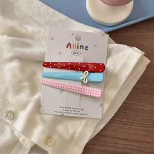 Detailed view of a 3pcs hair clip set featuring red dots, blue bow, and pink plaid patterns
