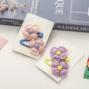 Barrettes à fleurs en tissu fait main en rose et violet sur cartes de présentation