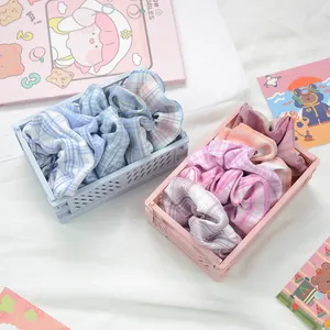 Gros plan de chouchous à carreaux en tissu dans des caisses pastel avec accessoires