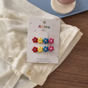 Detailed view of colorful floral hair clips with sparkling rhinestones on display card