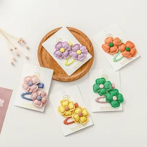 Détail de pinces à cheveux en tissu faites main aux couleurs vives sur plateau bois