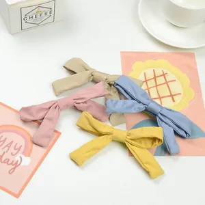 Flat lay of colorful fabric bow hair clips set for girls on a soft aesthetic background