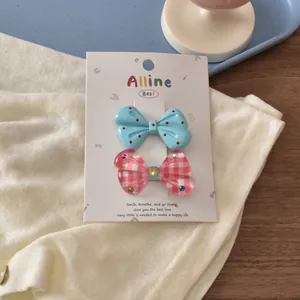 Detail of colorful bow hair clips set with blue polka dots and pink plaid patterns