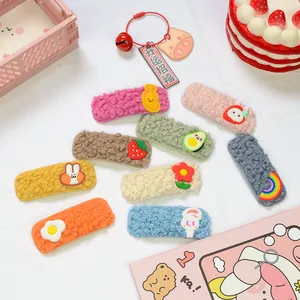 Vista dettagliata di otto fermagli per capelli in peluche colorati con graziosi ciondoli