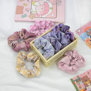 Détail de chouchous à carreaux colorés dans un mini panier de rangement jaune