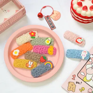 Dettaglio di fermagli in peluche colorati con decorazioni a cartone animato in resina