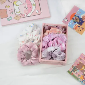 Ensemble de chouchous à fleurs et carreaux dans un petit panier de rangement rose