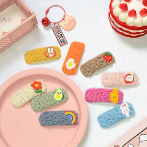 Dettaglio di fermagli per capelli in peluche colorati con ciondoli 3D e morbida lana agnello