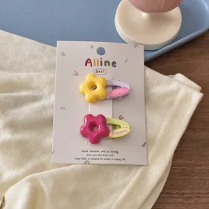 Detail view of cute flower hair clips with Hello and Puppies text on a display card